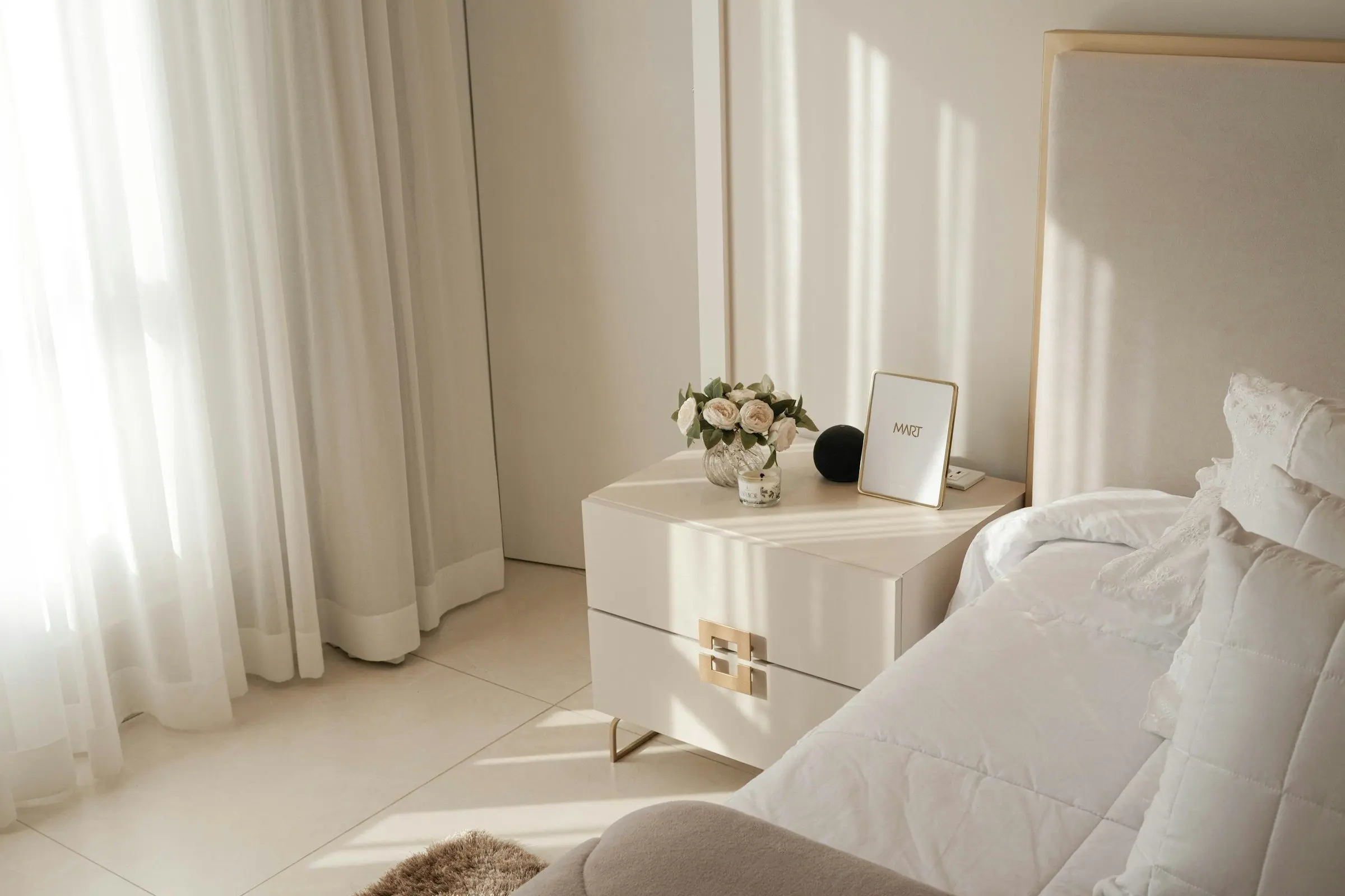 Dormitorio preparado con luz de mañana y flores